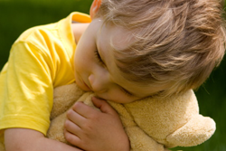 boy cuddling a teddy bear